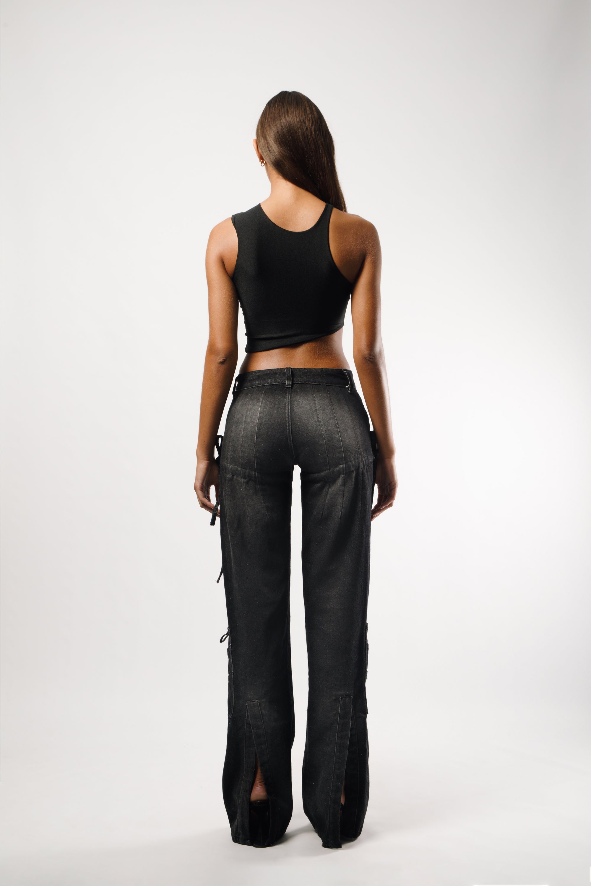   Long pants in washed black cotton with darts and opening slits on the back, adjustable cords to embellish the silhouette - back