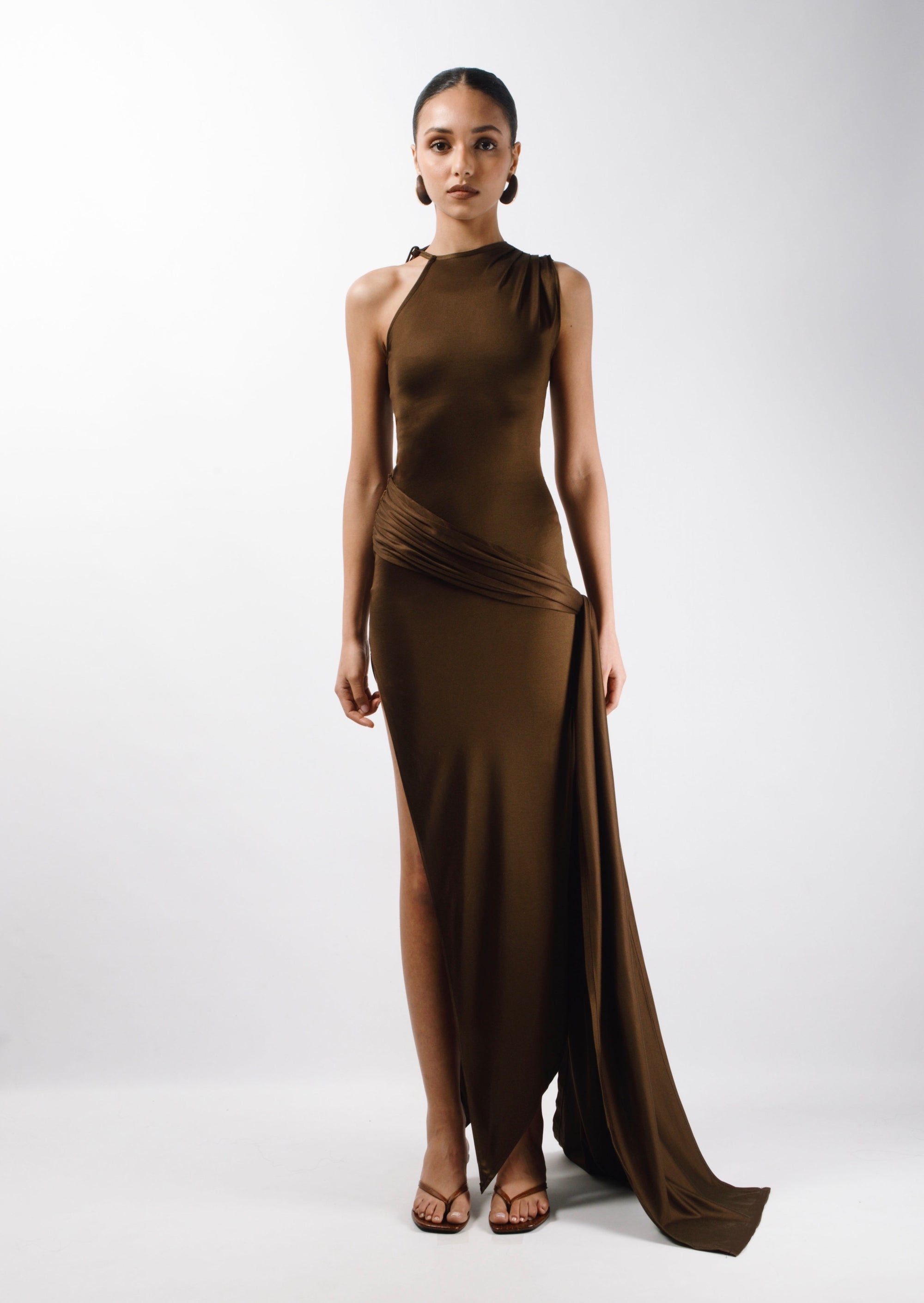Long Asymmetric Dress in brown Gold Silk fabric with a pleated sleeve and an adjustable sleeve, the Dress features a long train attached from the waist and an opening slit that hits at the ankle - front