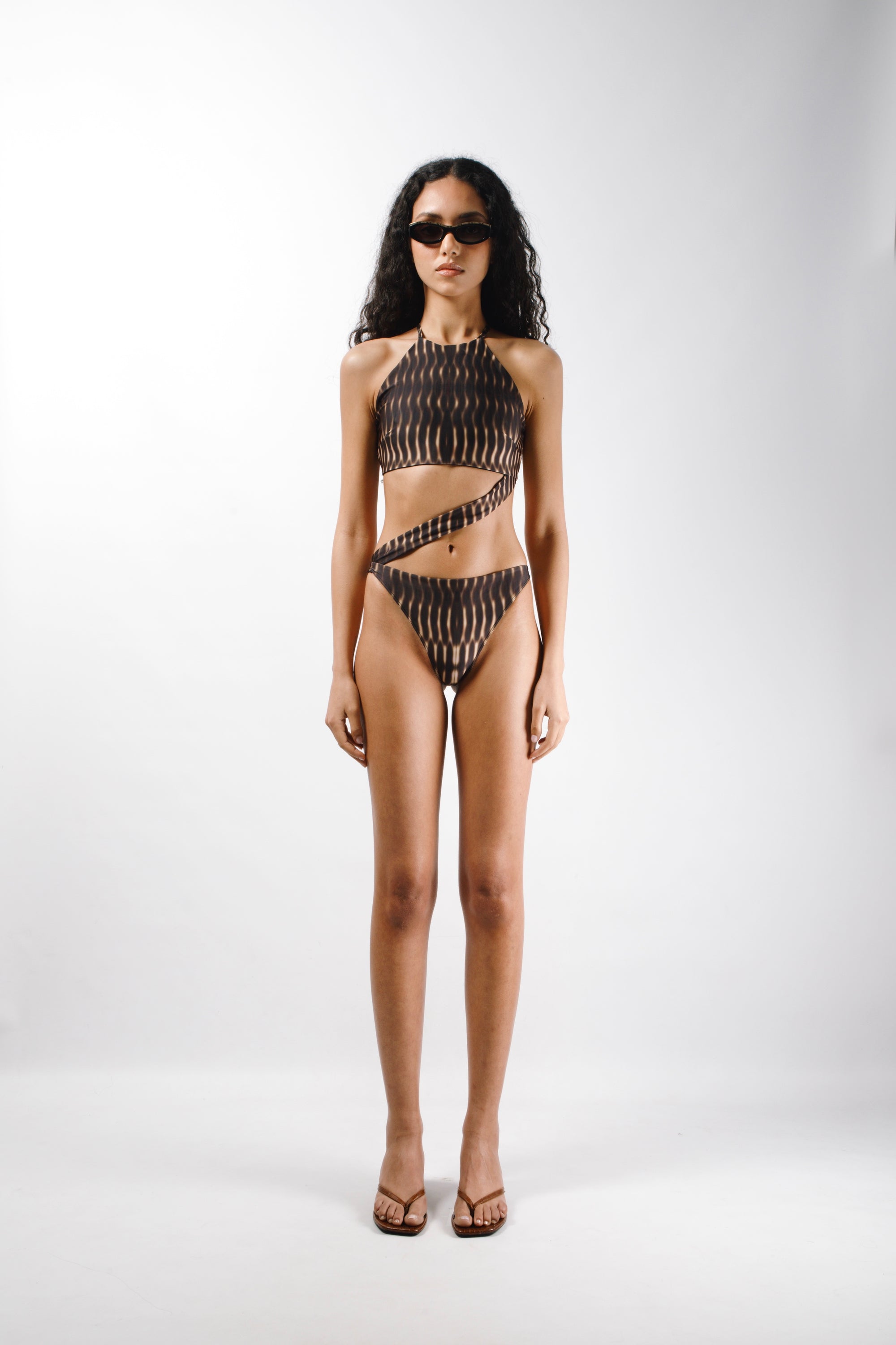 One-piece in Gold sunbeams printed lycra made from recycled plastic bottles with logo metal ends - front