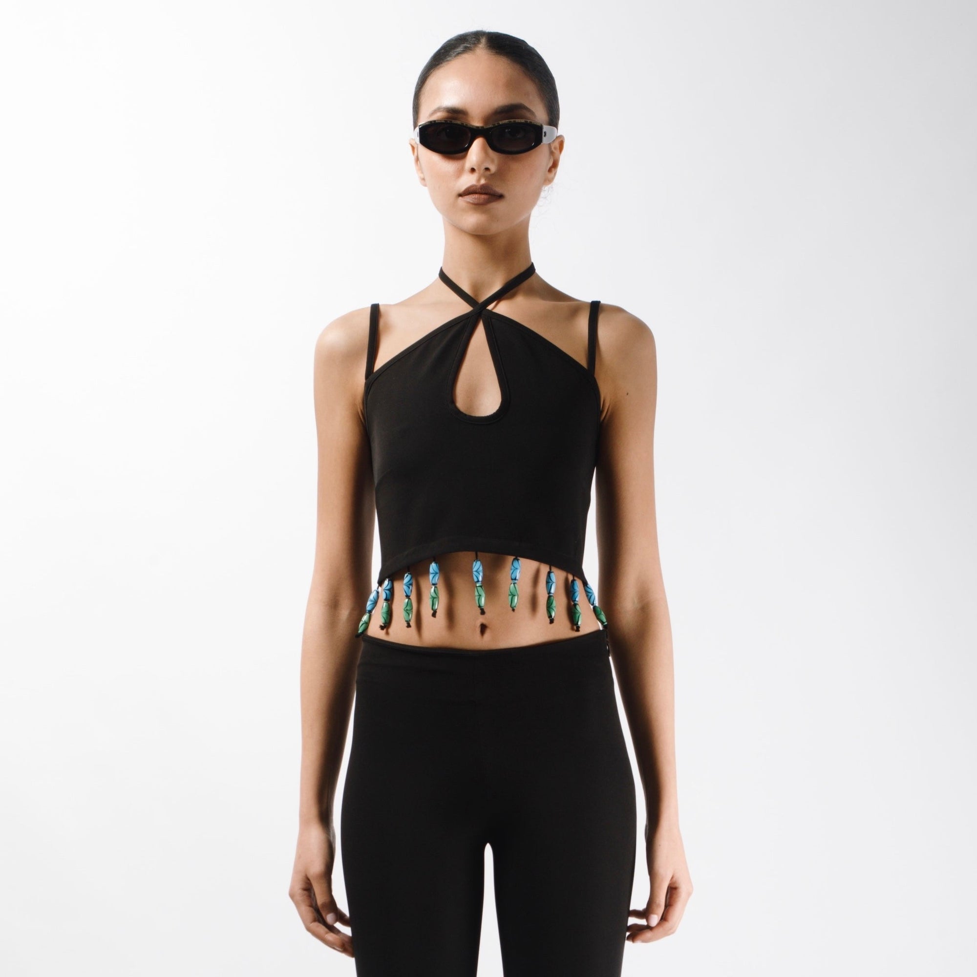 Fitted Crop top with crossed tie strap and thin bretelles, embelished with bead fringes on the hem and a zip on the back - front